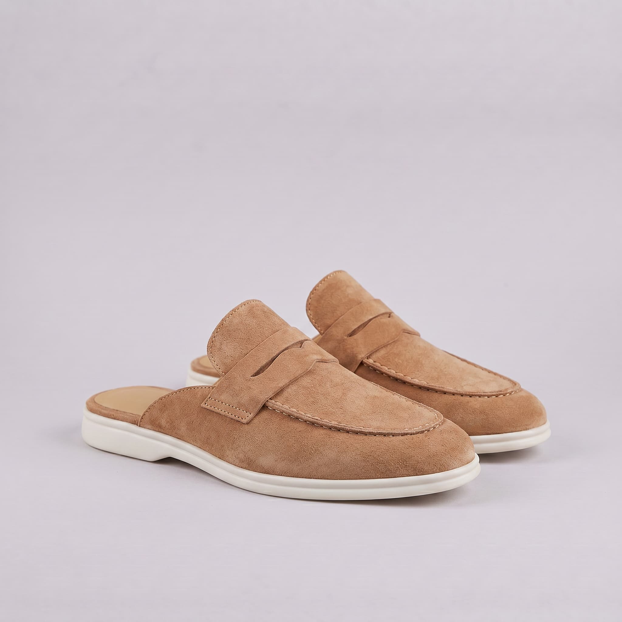 Pair of brown suede shoes on a light gray background