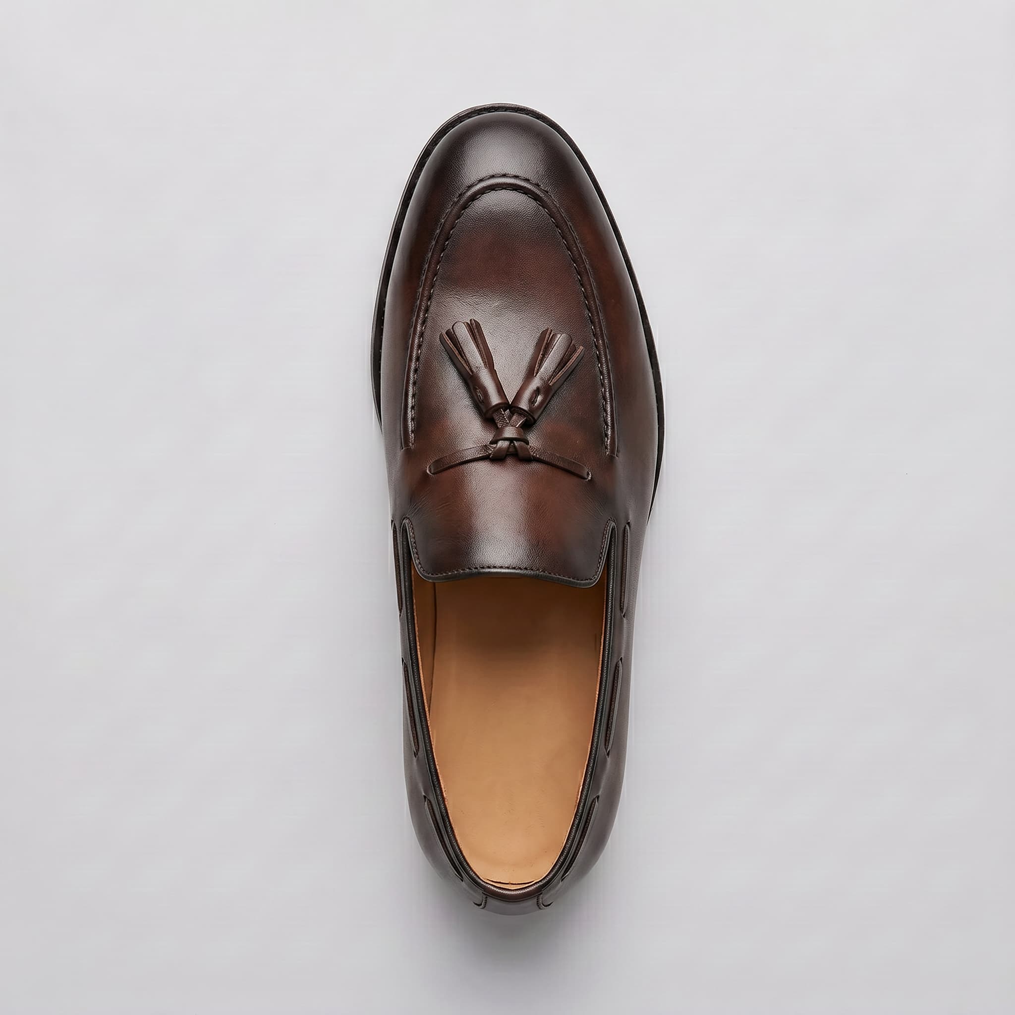 Brown leather loafer shoe on a light gray background