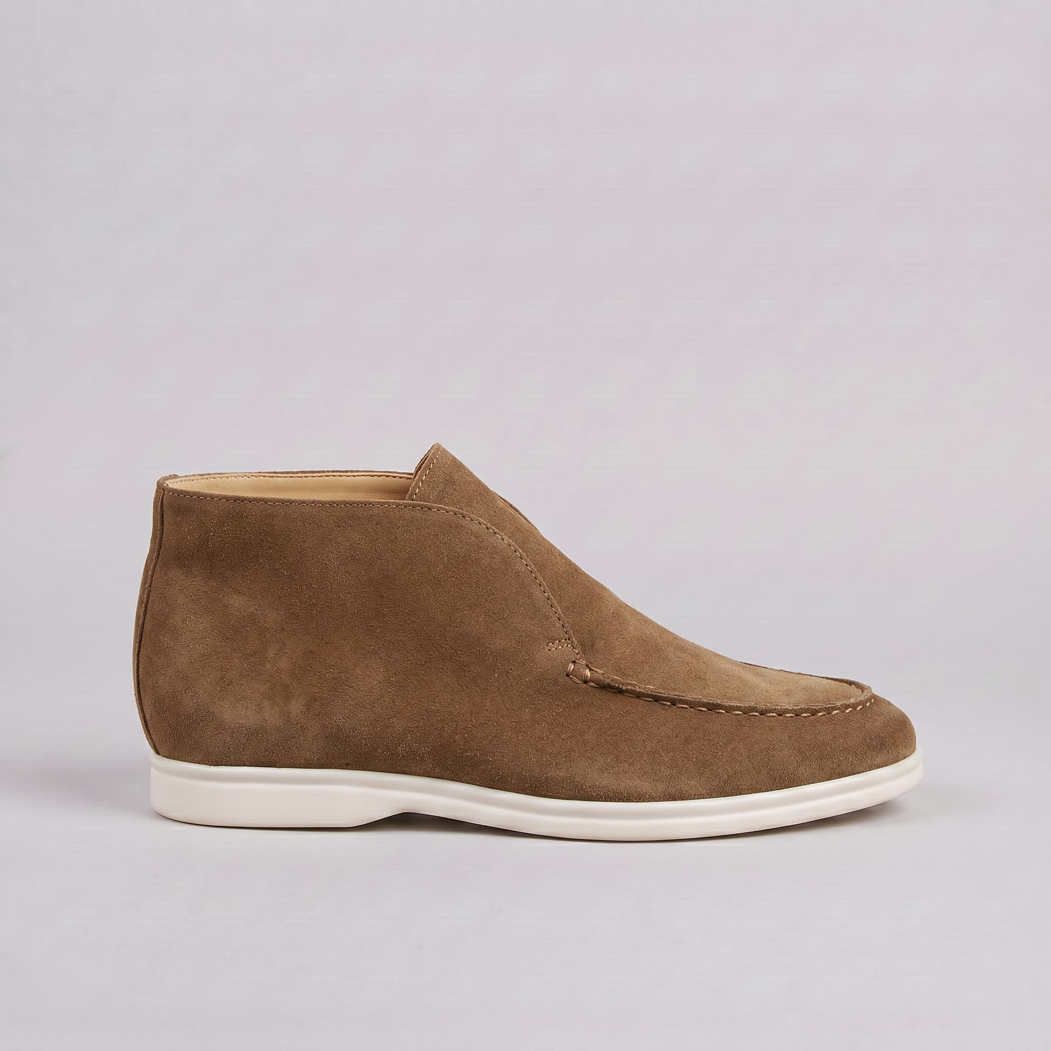 Brown suede shoe on a light gray background