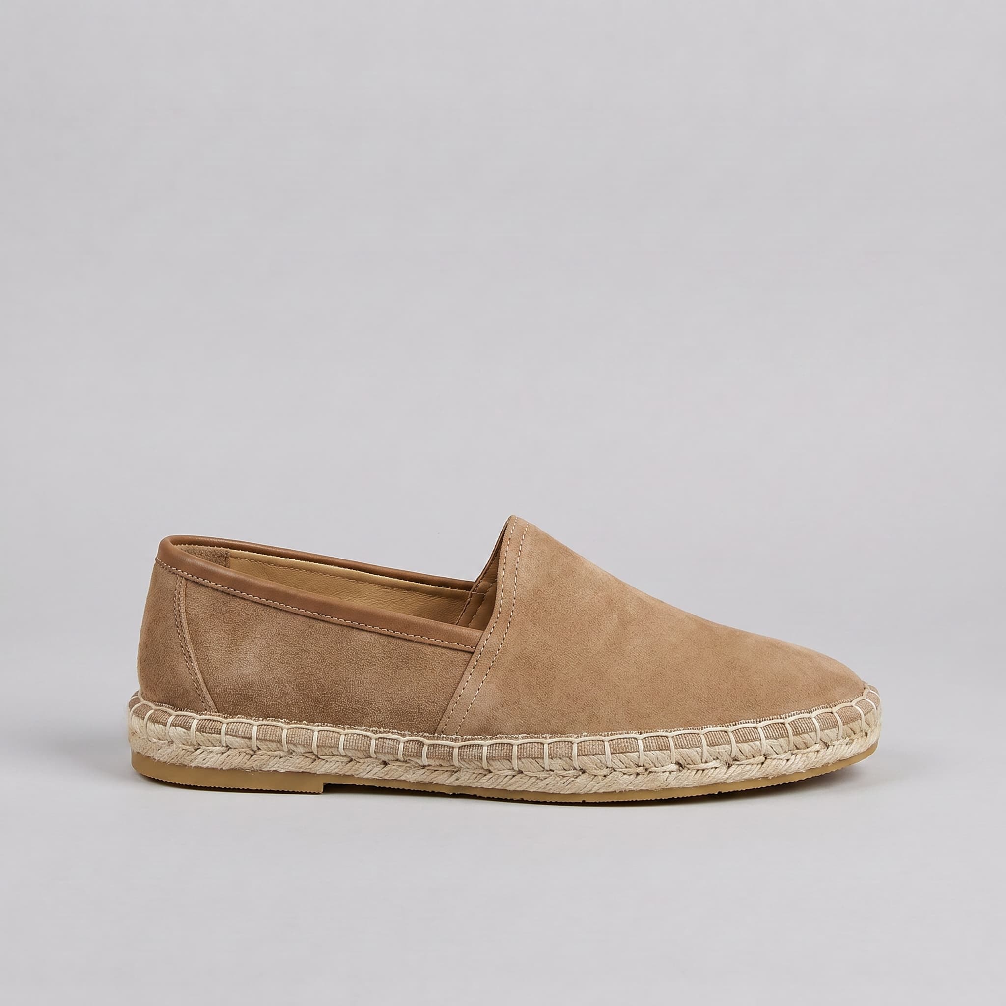 Tan espadrille shoe on a gray background
