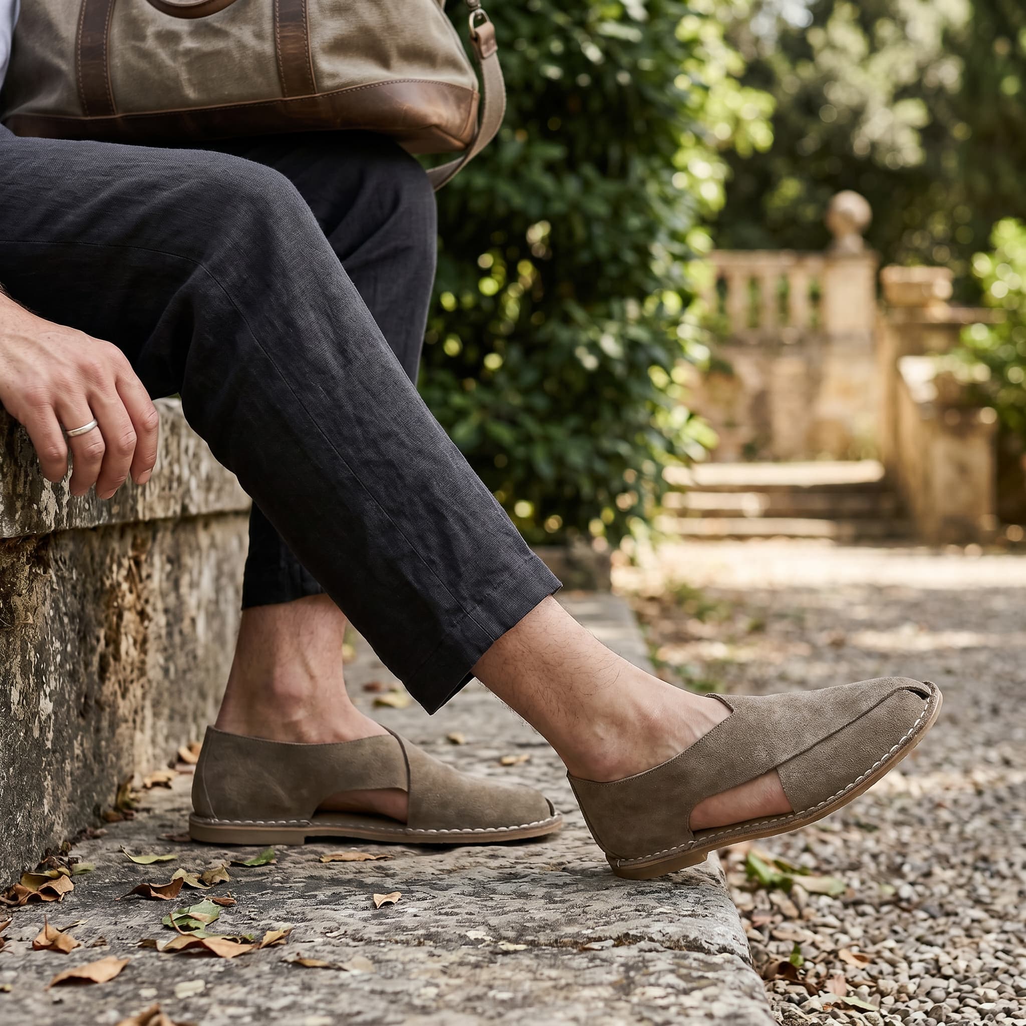 Person wearing brown loafers sitting outdoors with a blurred background