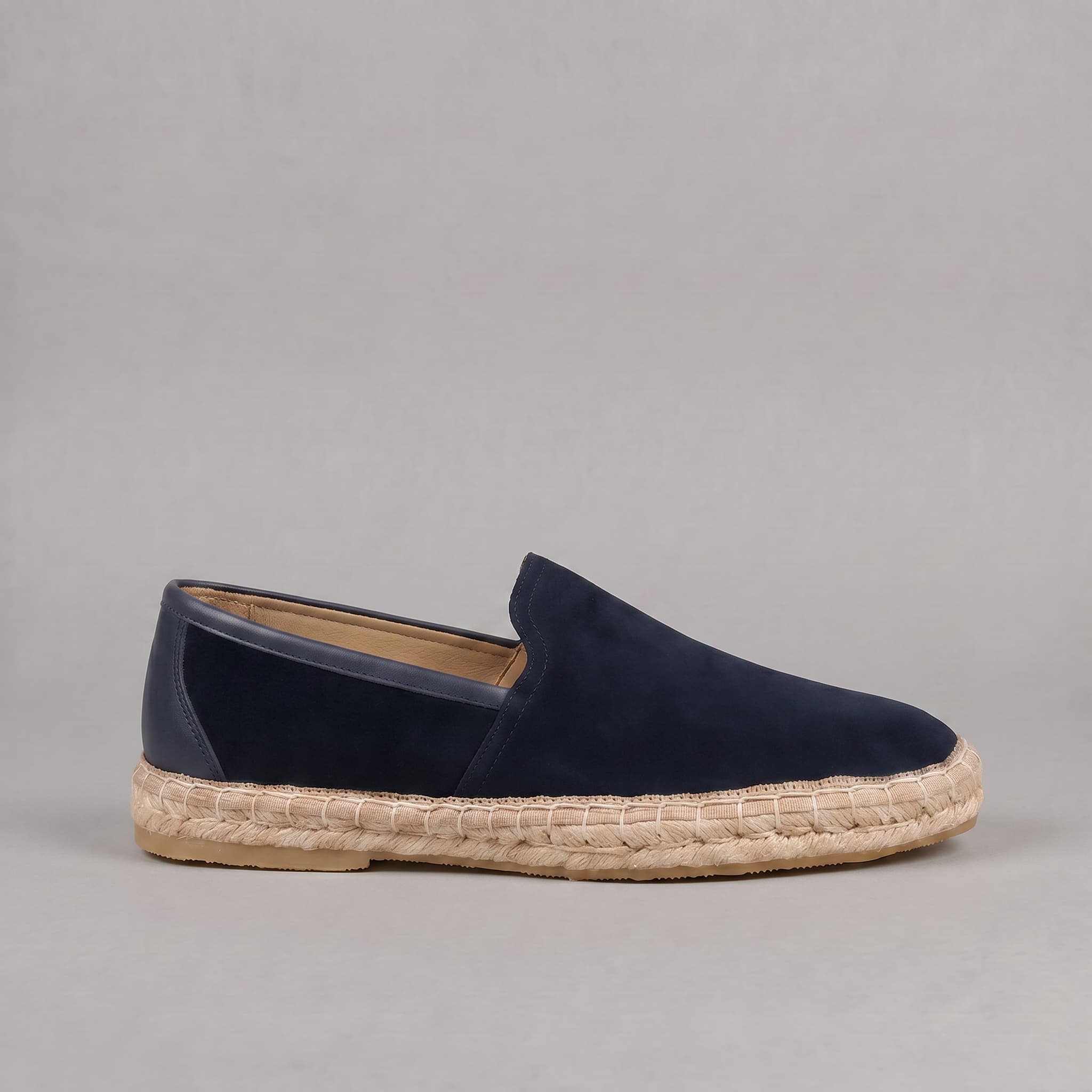 Navy blue espadrille shoe on a gray background