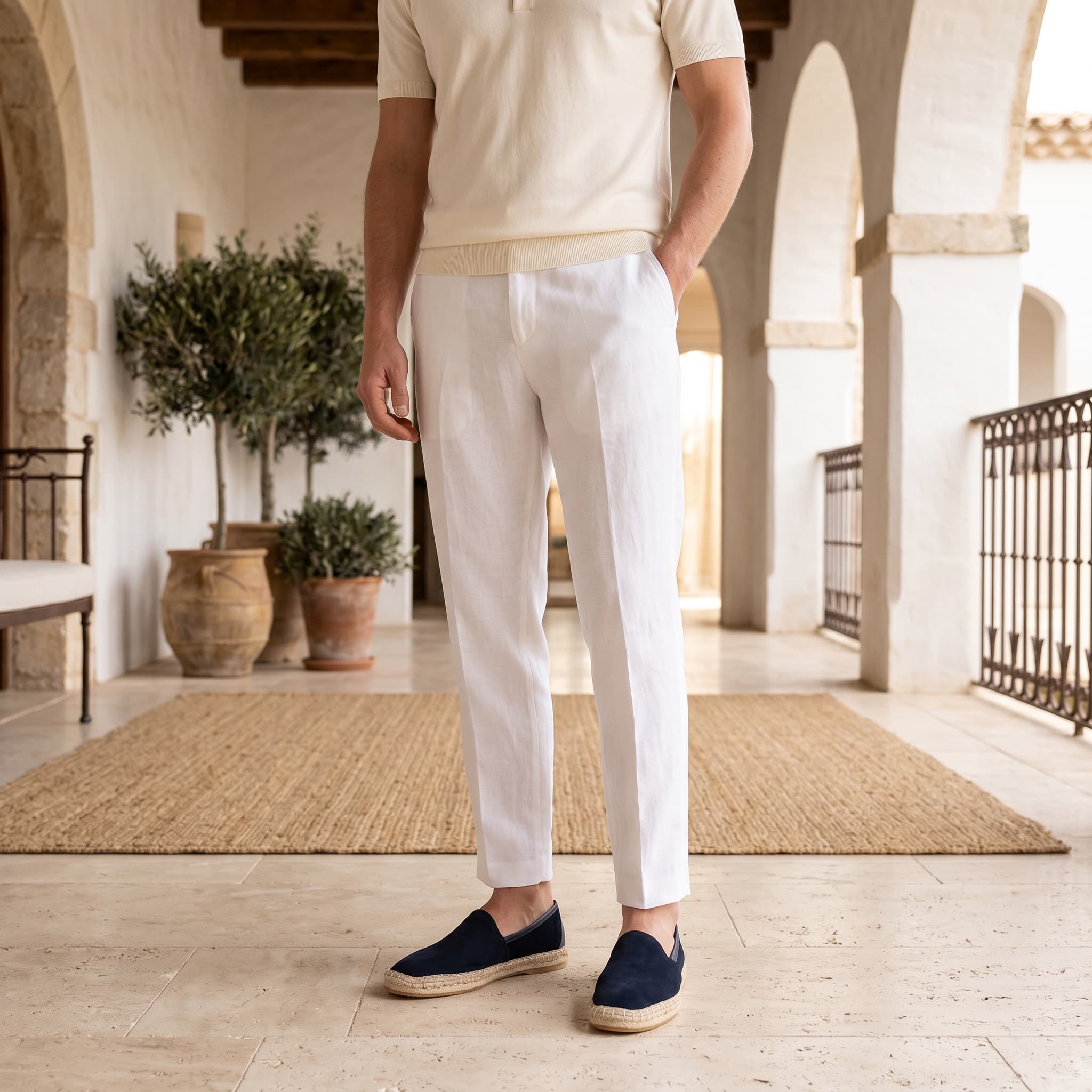 Man wearing a white outfit with navy shoes in an outdoor setting
