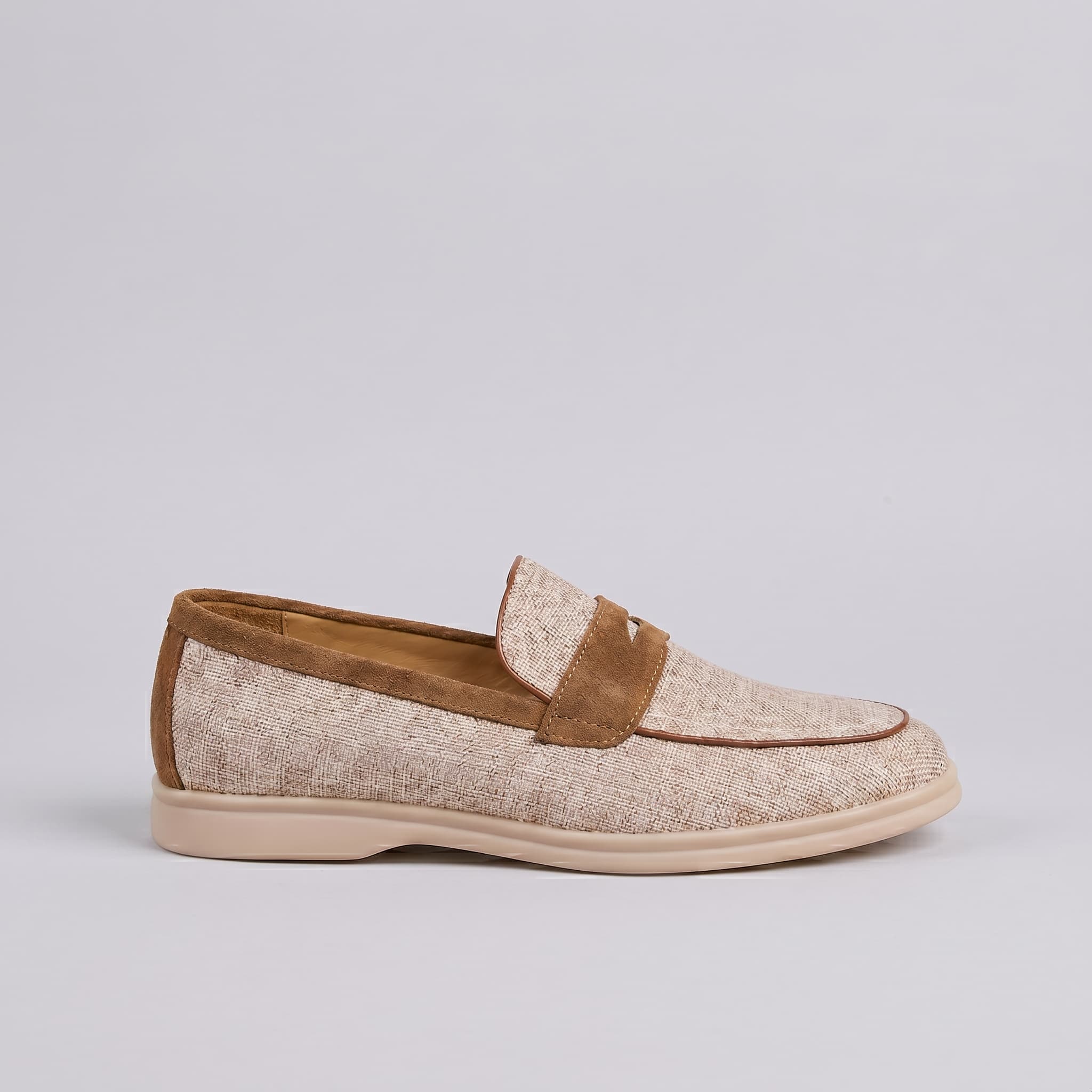 Loafer shoe with brown suede accents on a light gray background