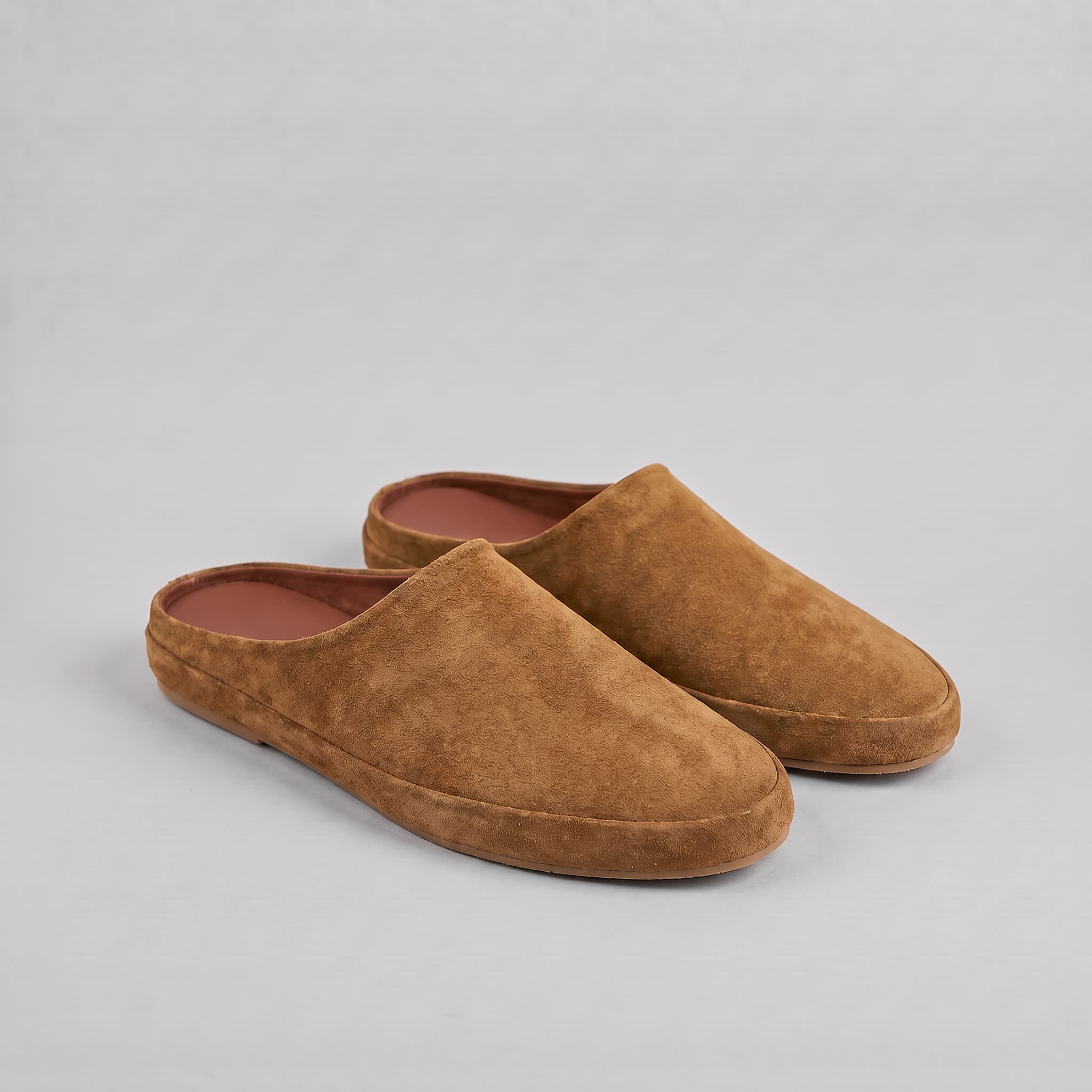 Pair of brown slippers on a gray background