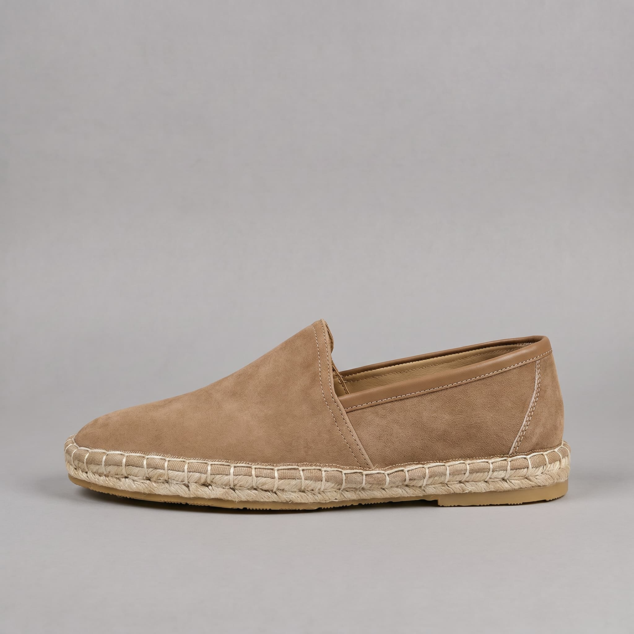 Tan espadrille shoe on a gray background