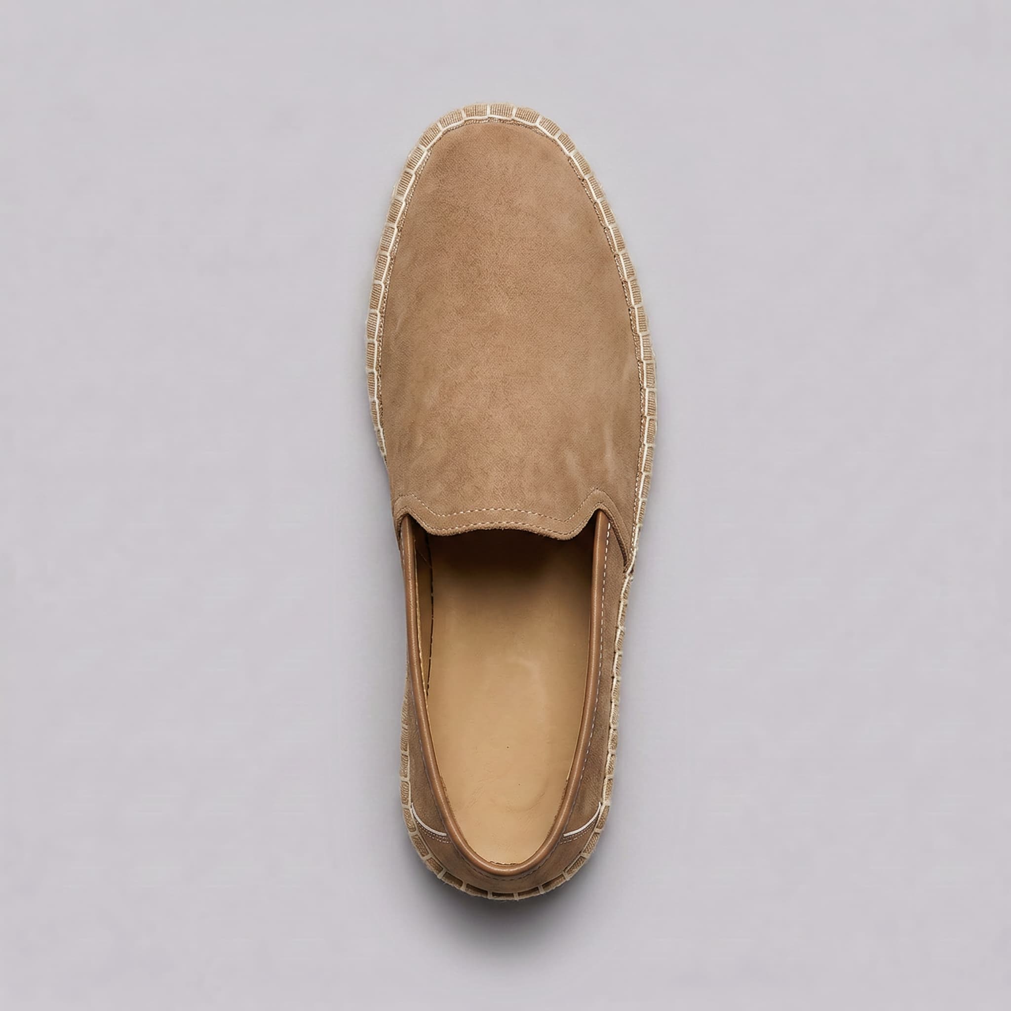 Brown suede slip-on shoe on a gray background