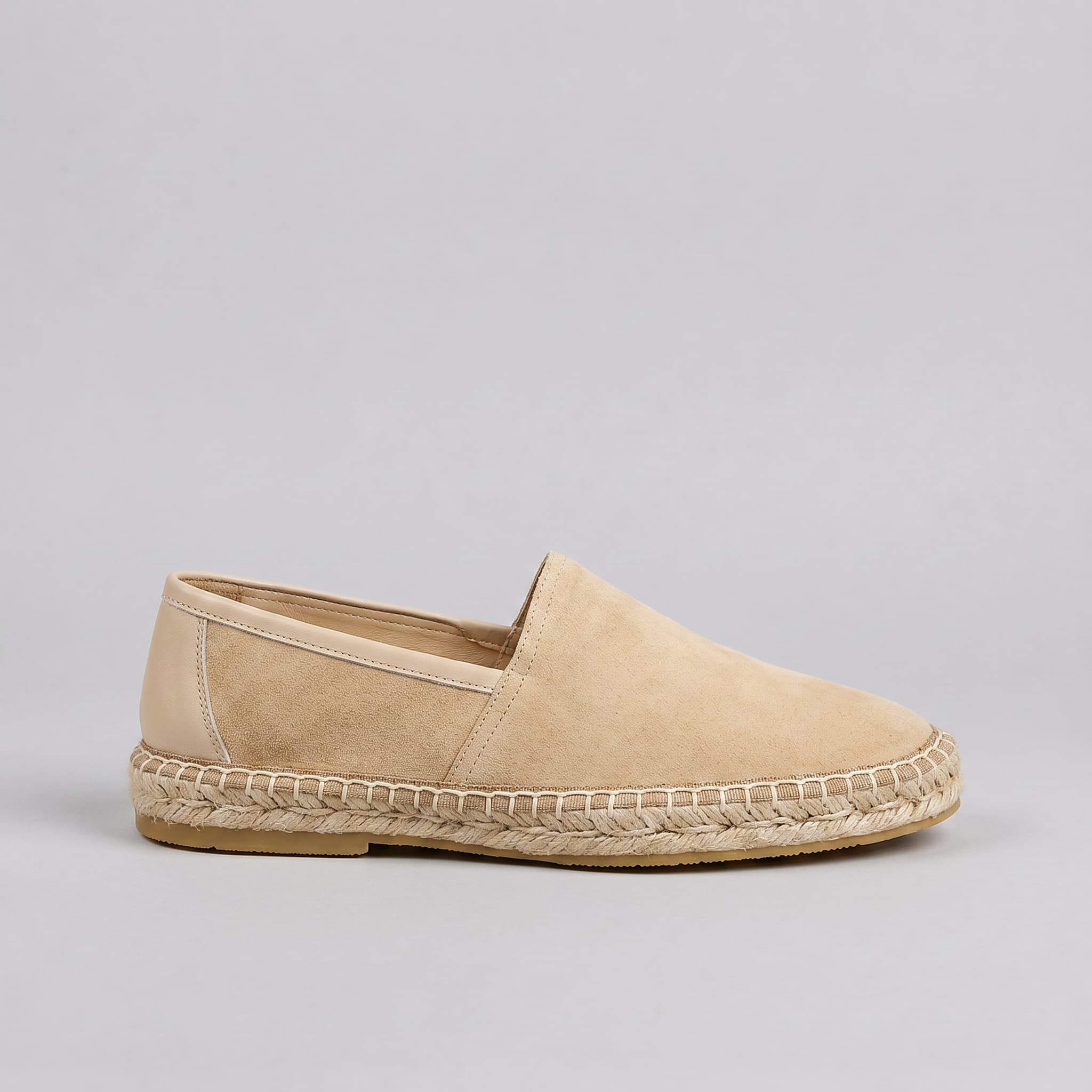 Beige espadrille shoe on a gray background