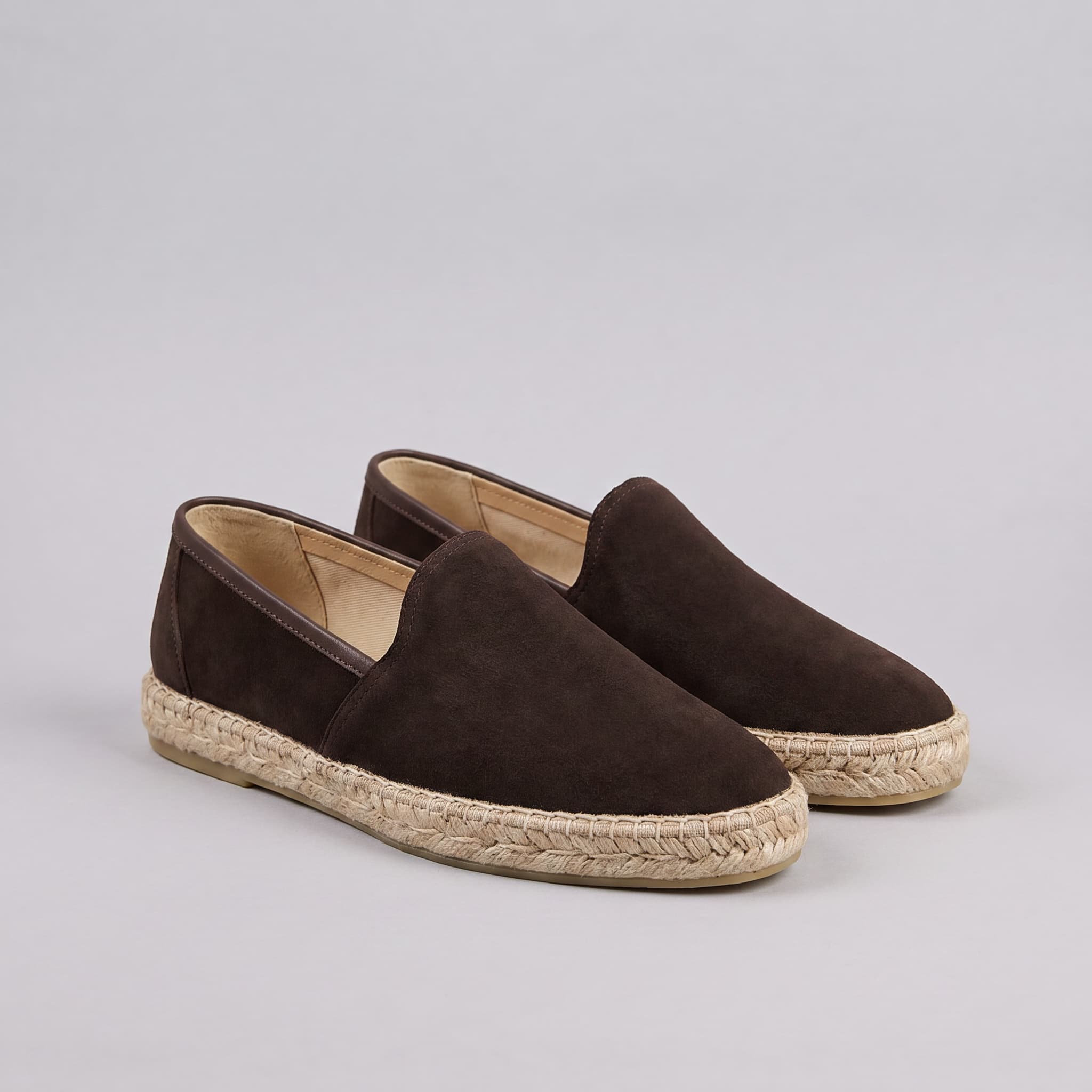 Pair of brown espadrilles on a gray background