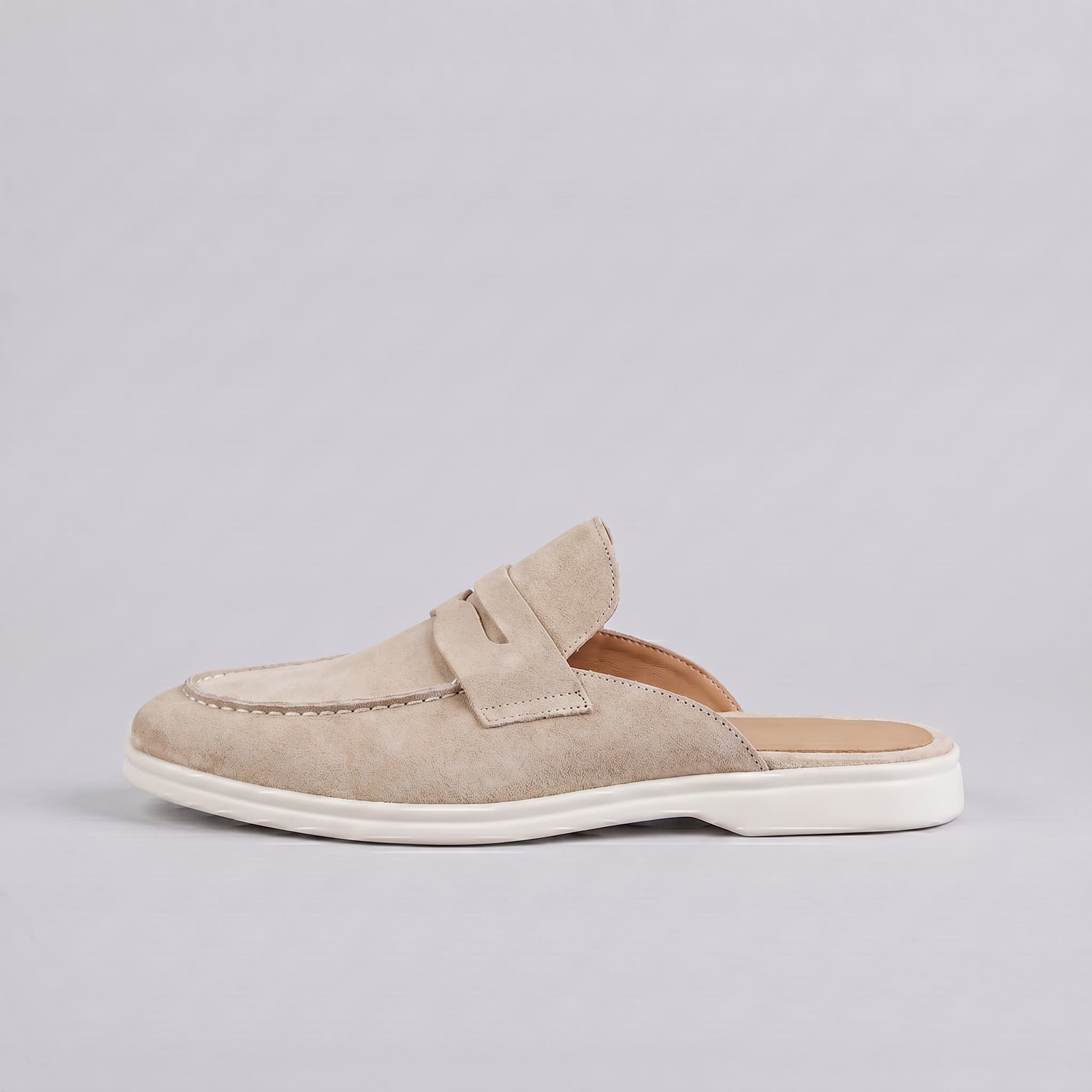 Beige slip-on shoe with a white sole on a light gray background