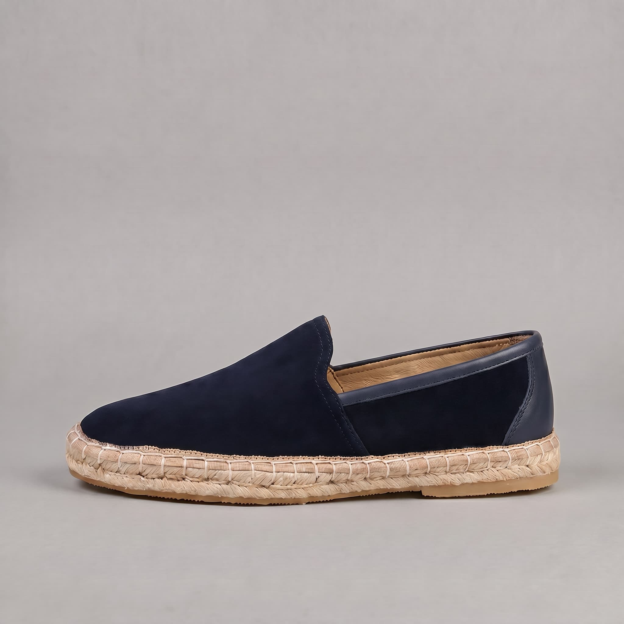 Navy blue loafer with jute sole on a gray background