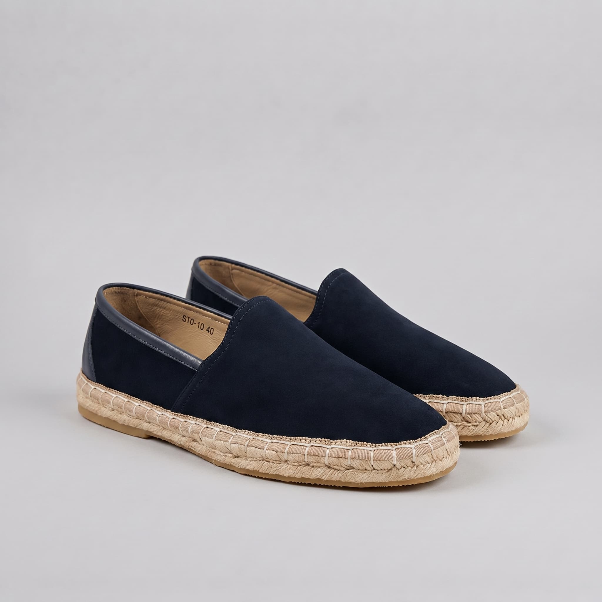 Pair of navy blue espadrilles on a gray background
