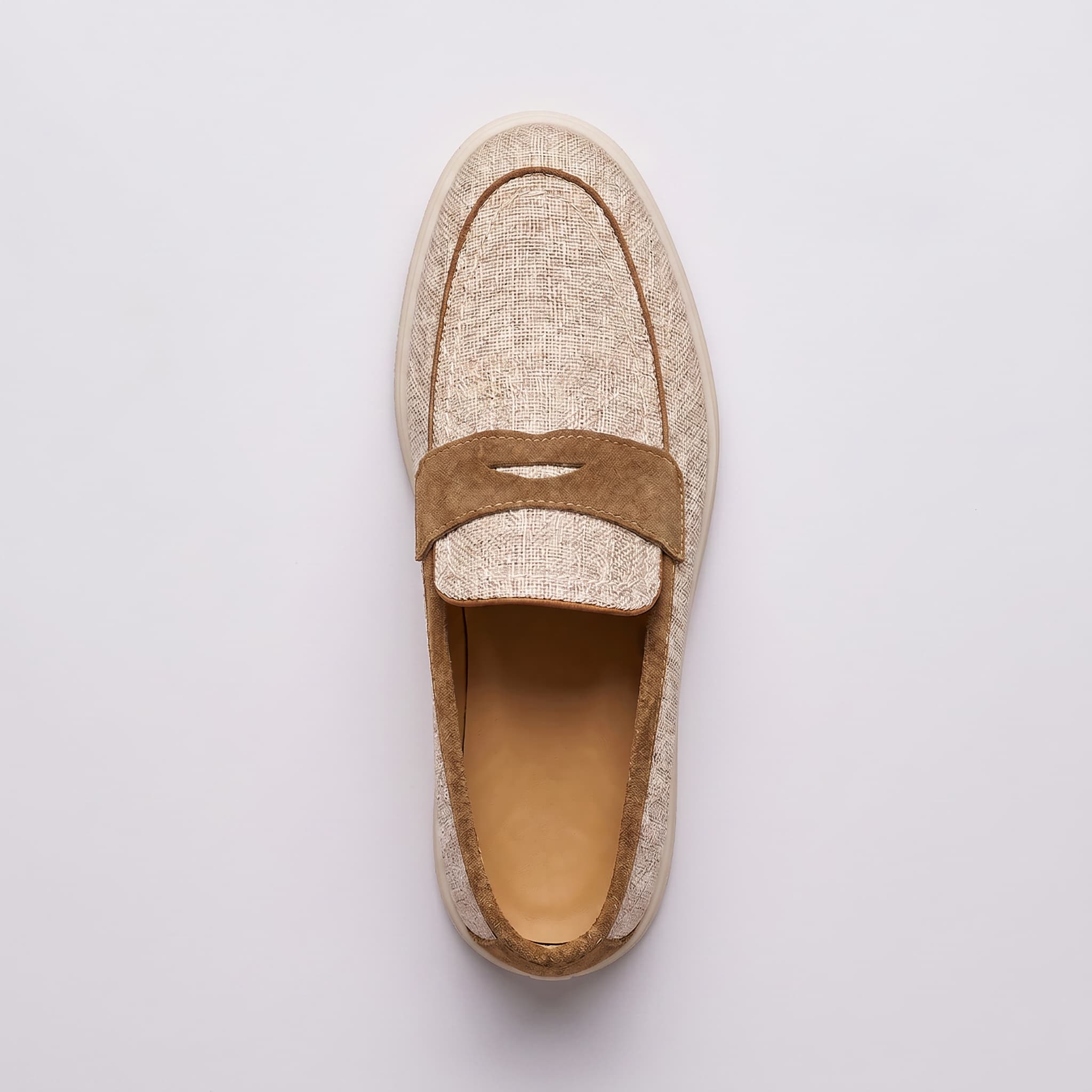 Beige slip-on shoe with brown band on a light gray background